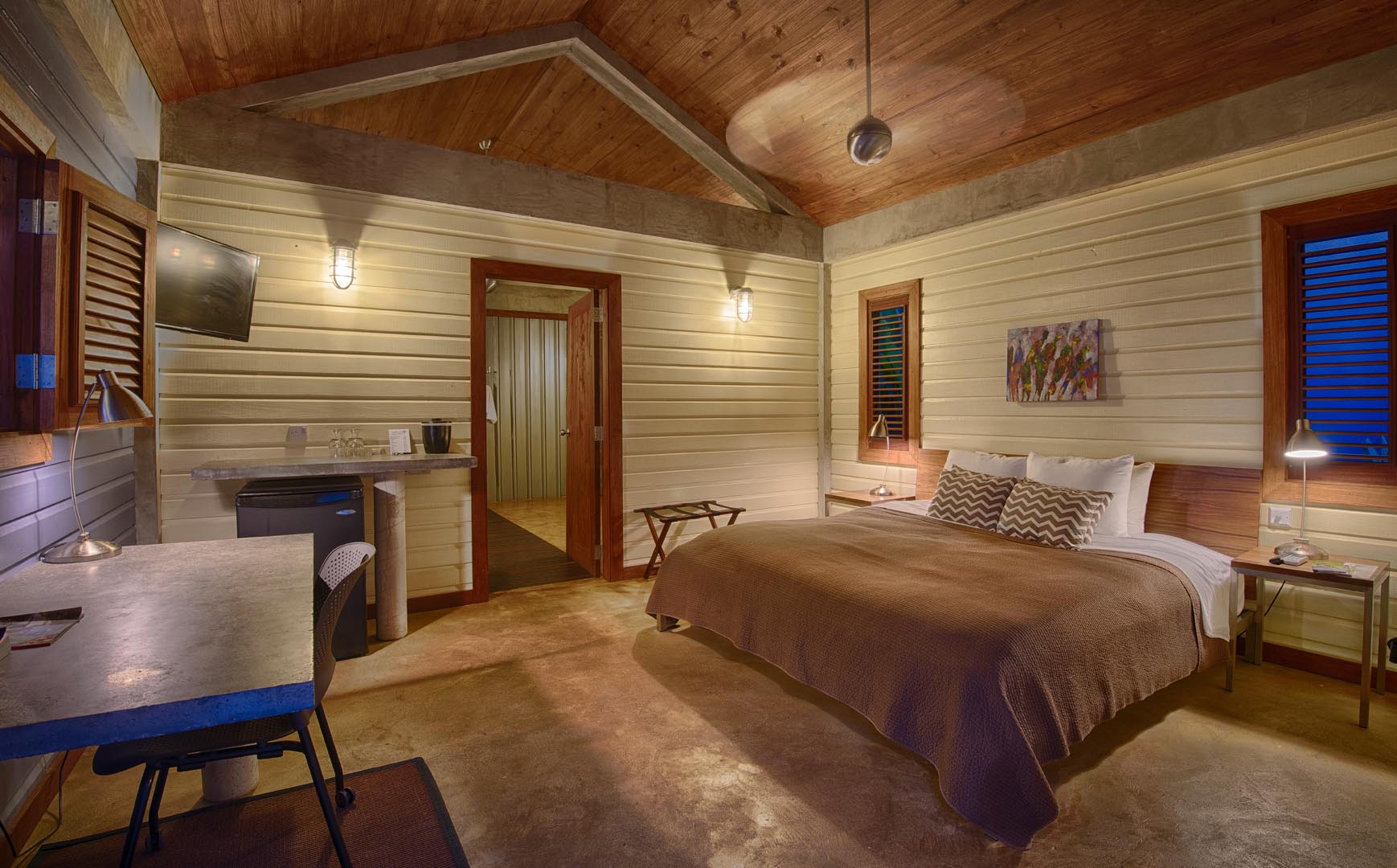 King bed with white feather bedding in Ocean Suite 6 at Pagua Bay House, oceanfront in Dominica